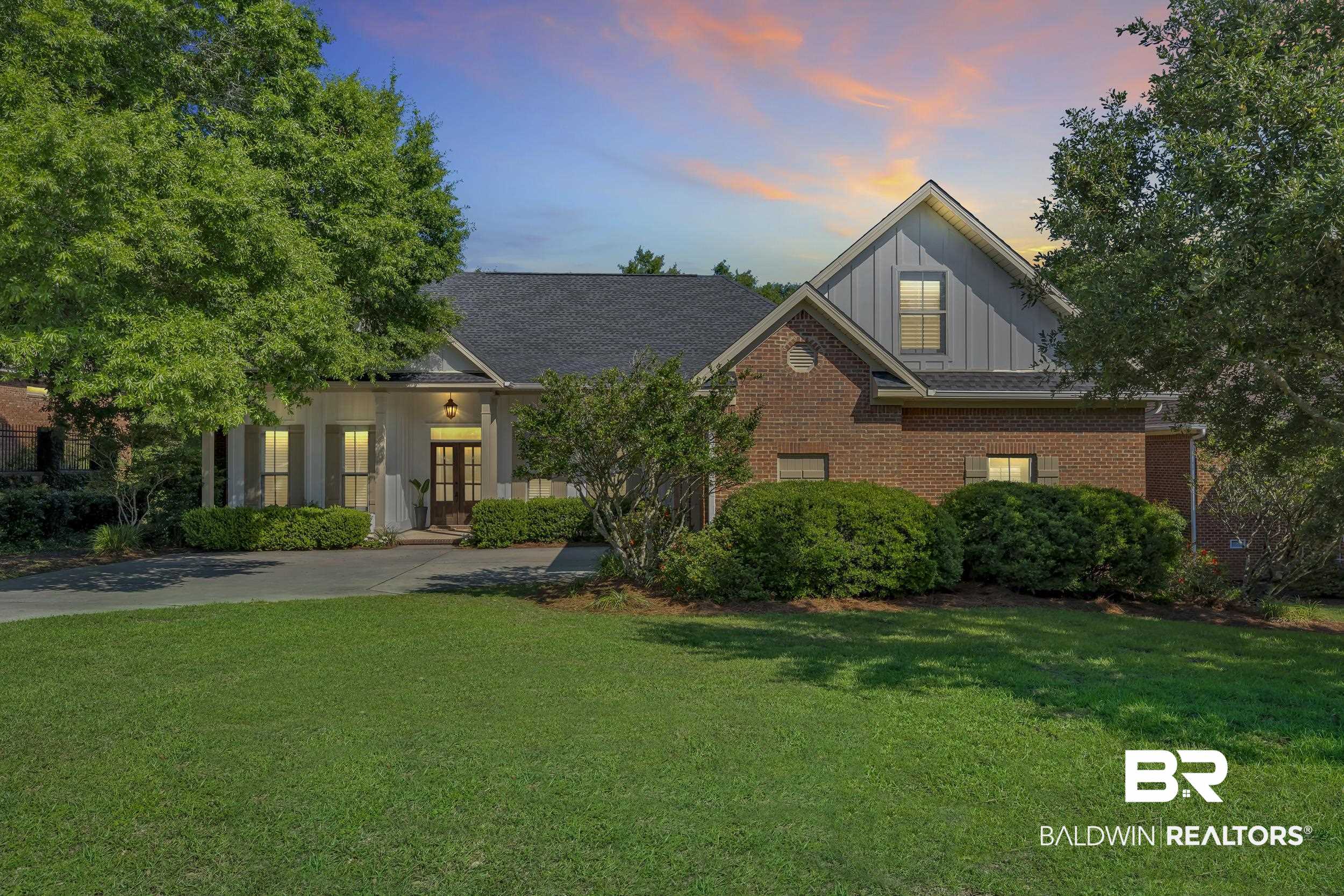 8137 Pine Run Daphne, AL 36527 - Photo 2 of 67 Brick and siding exterior featuring a covered front entry with columns, dark wood double doors, and a gabled roofline