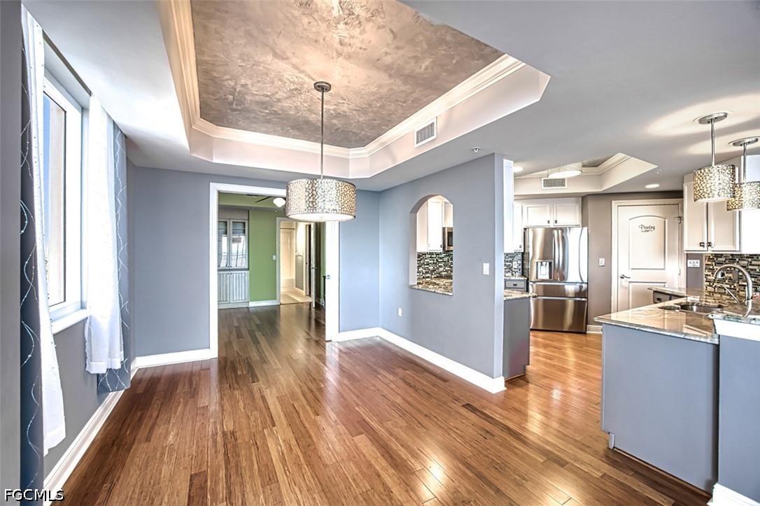 2104 West First Street, Unit 1004 Fort Myers, FL 33901 - Photo 15 of 42 a view of a big room with wooden floor and chandelier