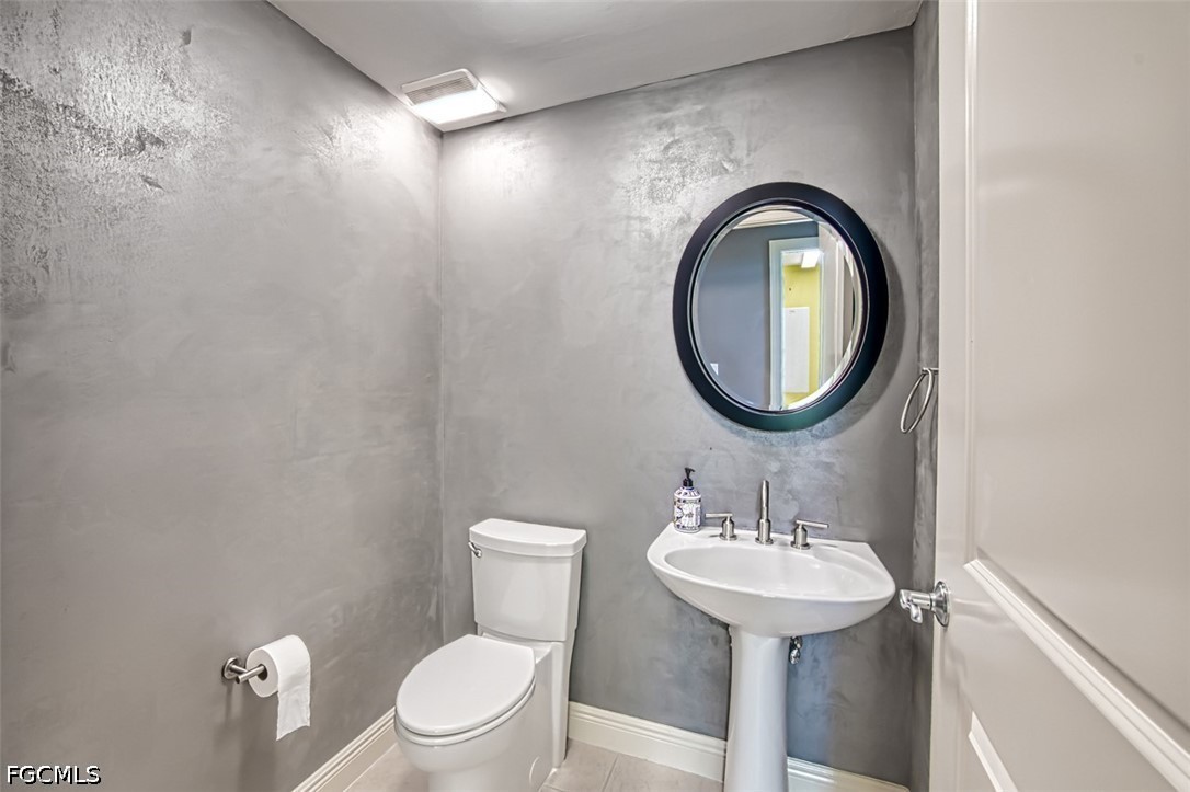 2104 West First Street, Unit 1004 Fort Myers, FL 33901 - Photo 18 of 42 a bathroom with a toilet a sink and a mirror