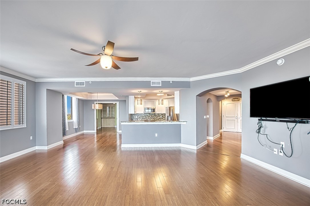 2104 West First Street, Unit 1004 Fort Myers, FL 33901 - Photo 23 of 42 a view of a livingroom with a flat screen tv wooden floor and a chandelier