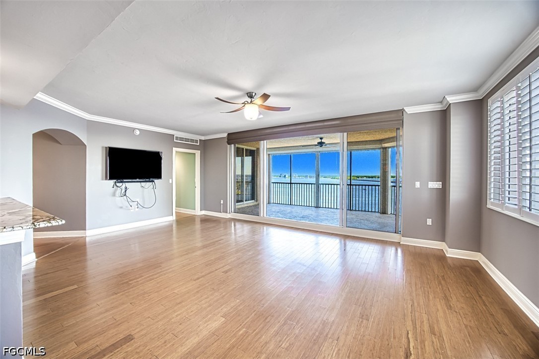 2104 West First Street, Unit 1004 Fort Myers, FL 33901 - Photo 7 of 42 a view of a livingroom with wooden floor and a flat screen tv