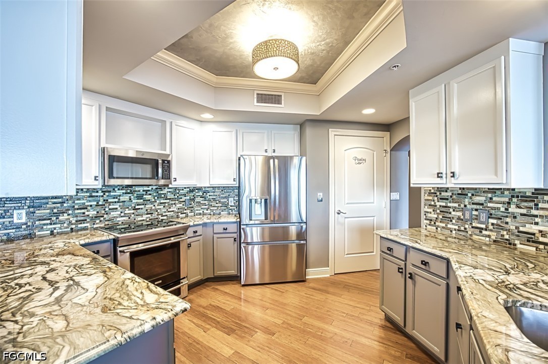 2104 West First Street, Unit 1004 Fort Myers, FL 33901 - Photo 9 of 42 a kitchen with stainless steel appliances kitchen island granite countertop a sink stove and refrigerator