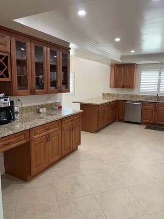 a large kitchen with stainless steel appliances granite countertop a large counter top and a stove top oven