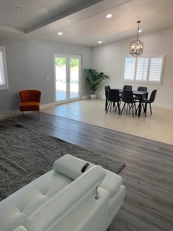a view of livingroom and dining room with furniture wooden floor and chandelier