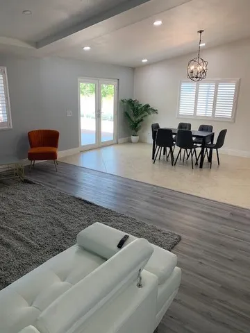 a view of livingroom and dining room with furniture wooden floor and chandelier