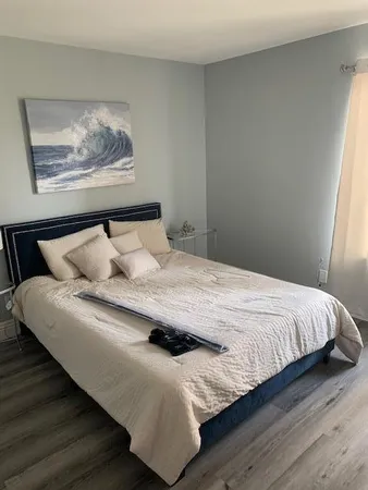 a bedroom with a bed and wooden floor