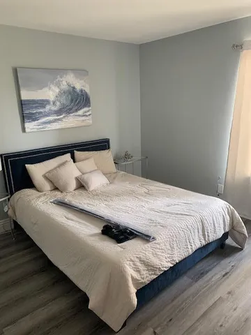 a bedroom with a bed and wooden floor