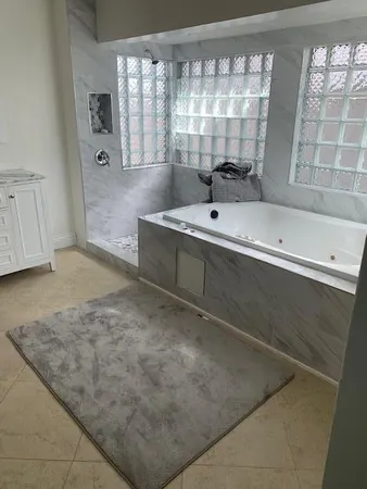 a view of bathroom with bathtub and shower