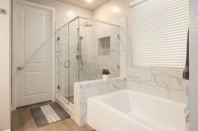 a bathroom with a tub a sink and a shower