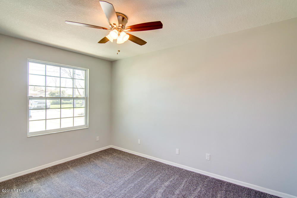 1634 Derringer Road Jacksonville, FL 32225 - Photo 26 of 41 an empty room with windows and ceiling fan