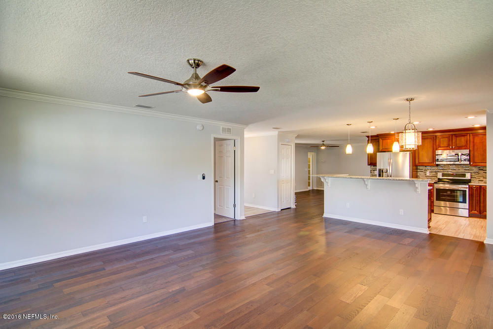 1634 Derringer Road Jacksonville, FL 32225 - Photo 8 of 41 a view of an empty room and kitchen view with wooden floor