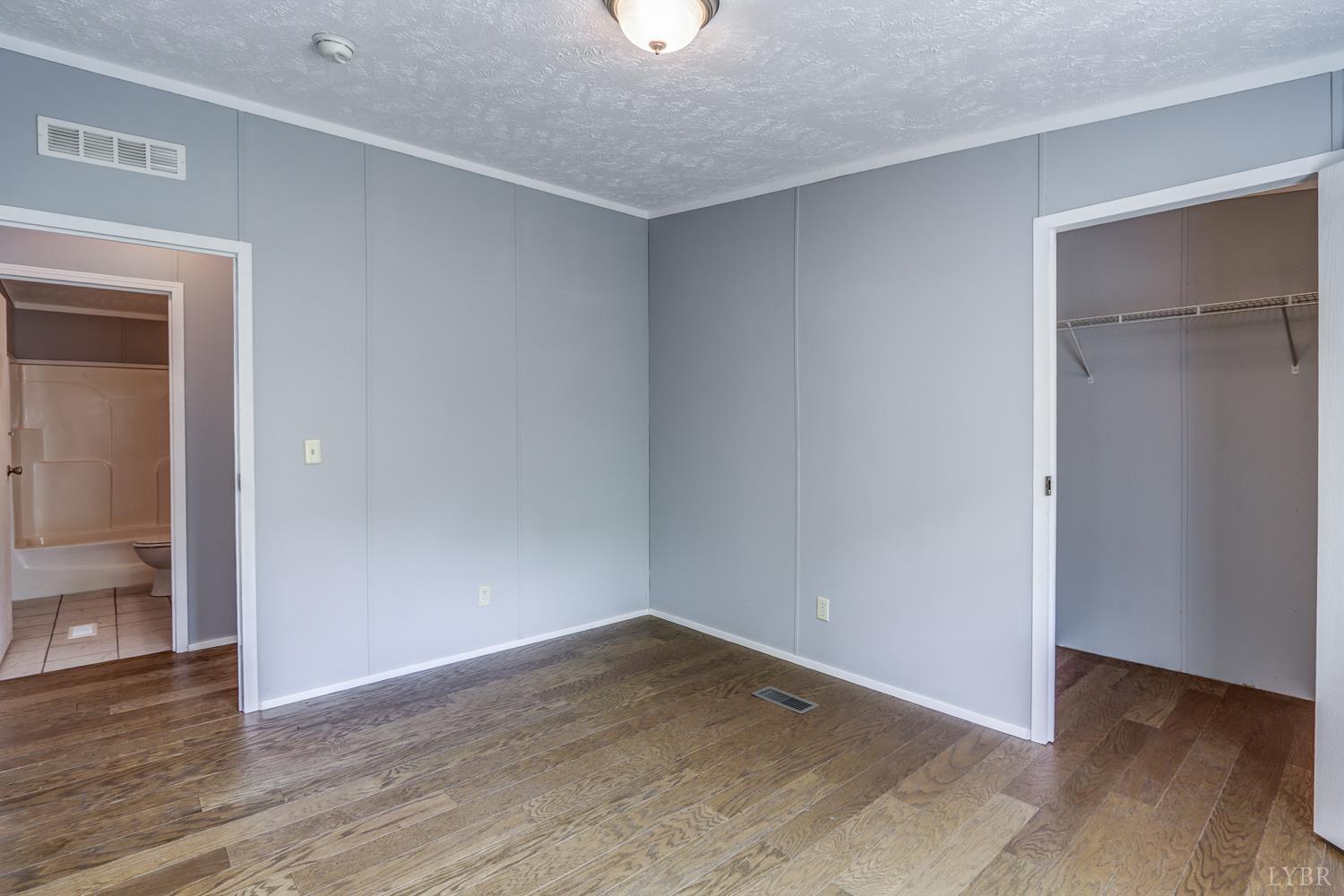 102 Slow Water Court Sandy Level, VA 24161 - Photo 34 of 66 a view of an empty room with wooden floor and a window