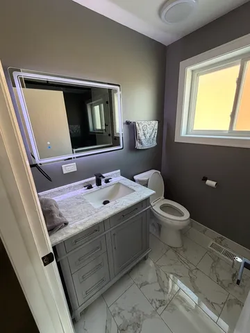 a bathroom with a toilet sink and mirror