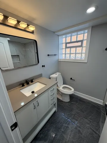 a bathroom with a sink toilet and window