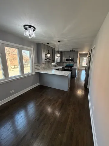 a kitchen with kitchen island granite countertop stainless steel appliances stove sink and cabinets
