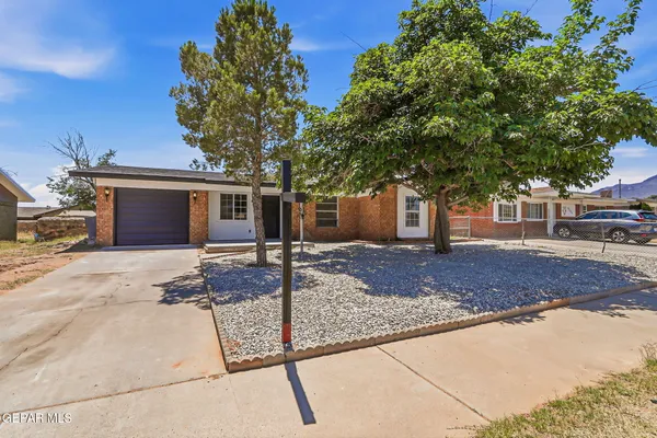 a front view of a house with a tree