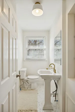 a bathroom with a sink toilet and a window