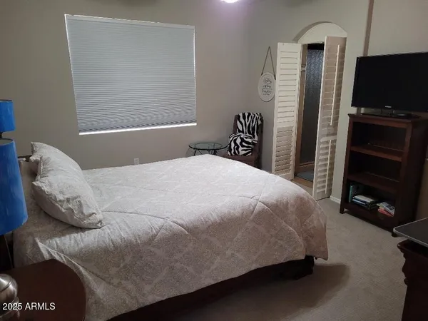 a bedroom with a bed and a television