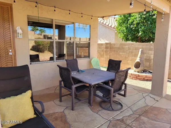 a view of an outdoor dining space with a table and chairs