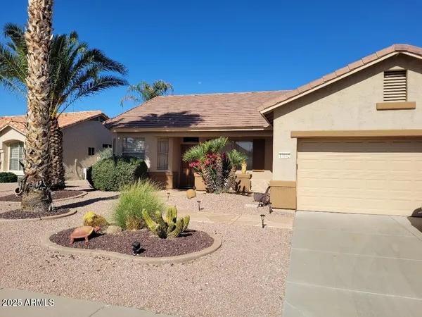 a view of a house with backyard and sitting area