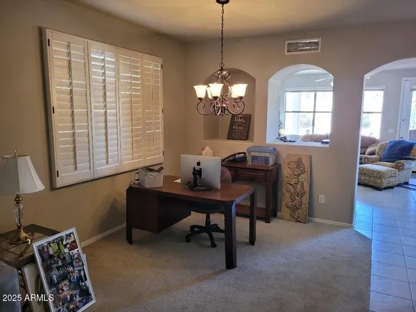 a view of a workspace with furniture and a window