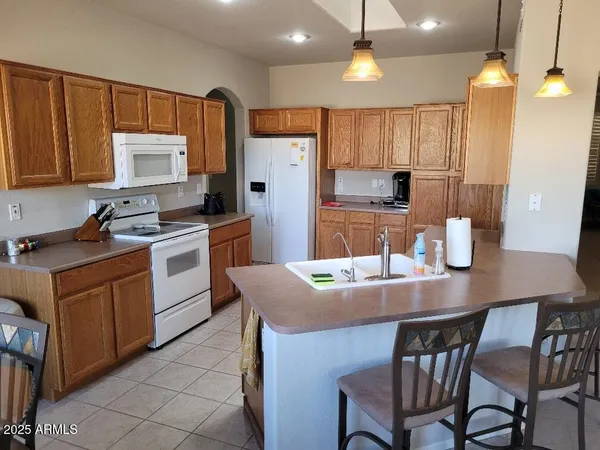 a kitchen with a table chairs refrigerator and microwave
