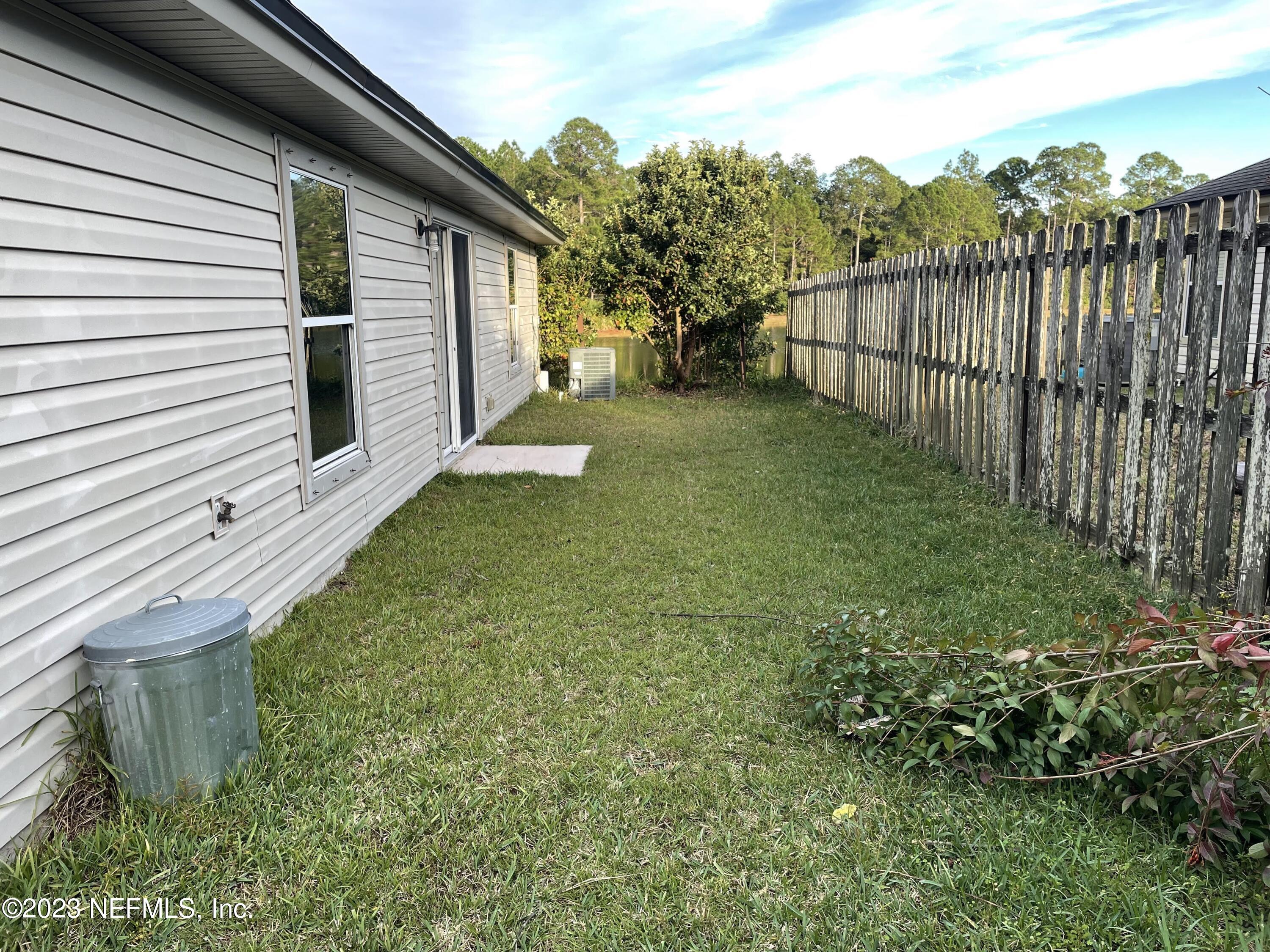86050 Sands Way Yulee, FL 32097 - Photo 13 of 15 a view of a backyard with wooden fence