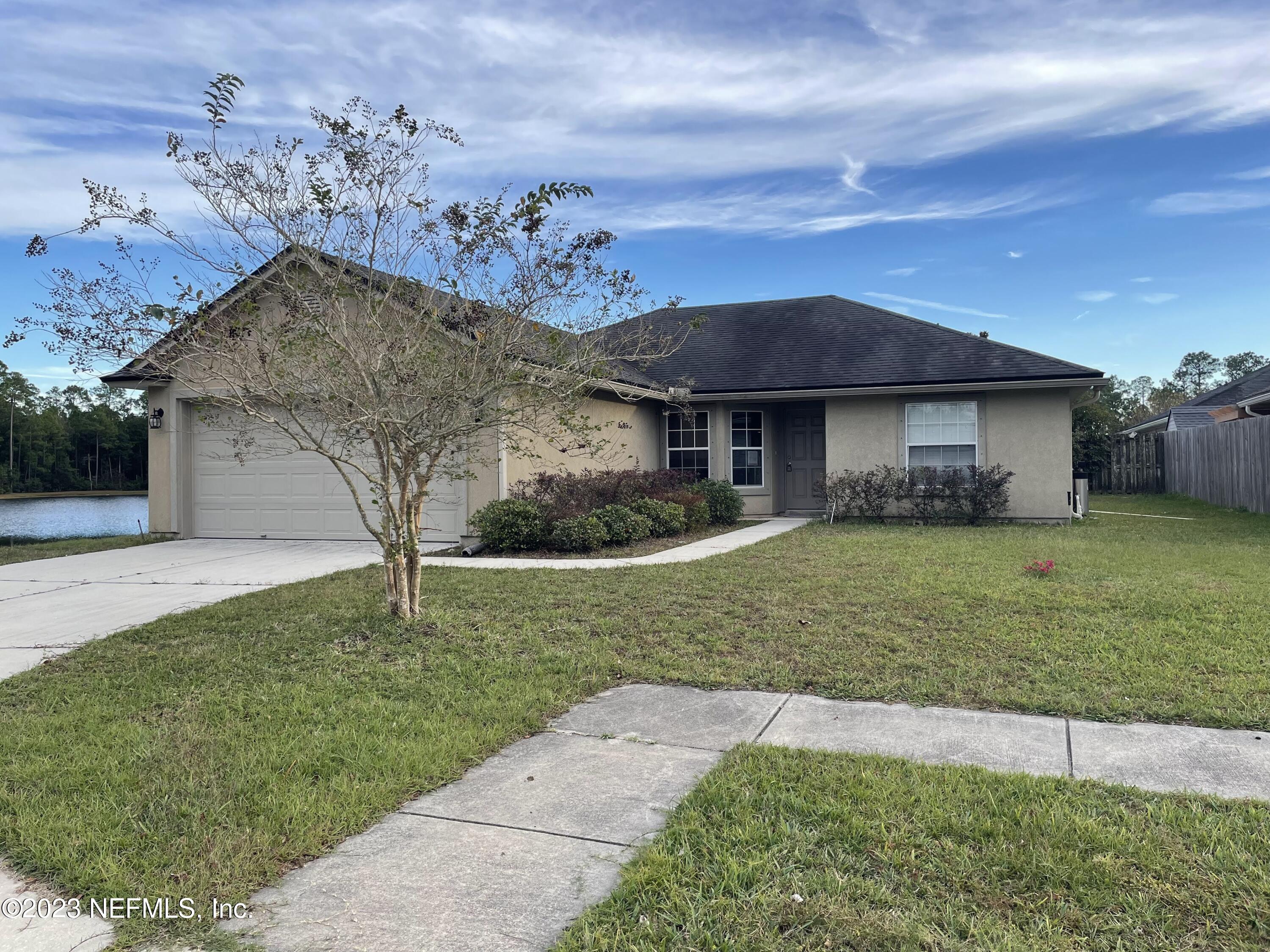 86050 Sands Way Yulee, FL 32097 - Photo 3 of 15 a front view of a house with a garden