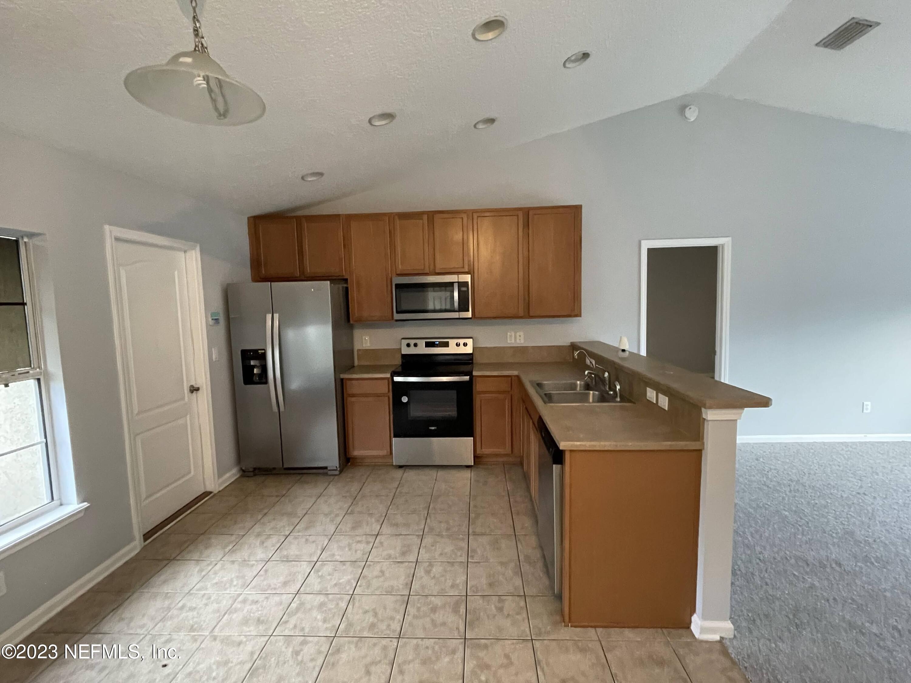 86050 Sands Way Yulee, FL 32097 - Photo 5 of 15 a kitchen with stainless steel appliances granite countertop a refrigerator and a stove