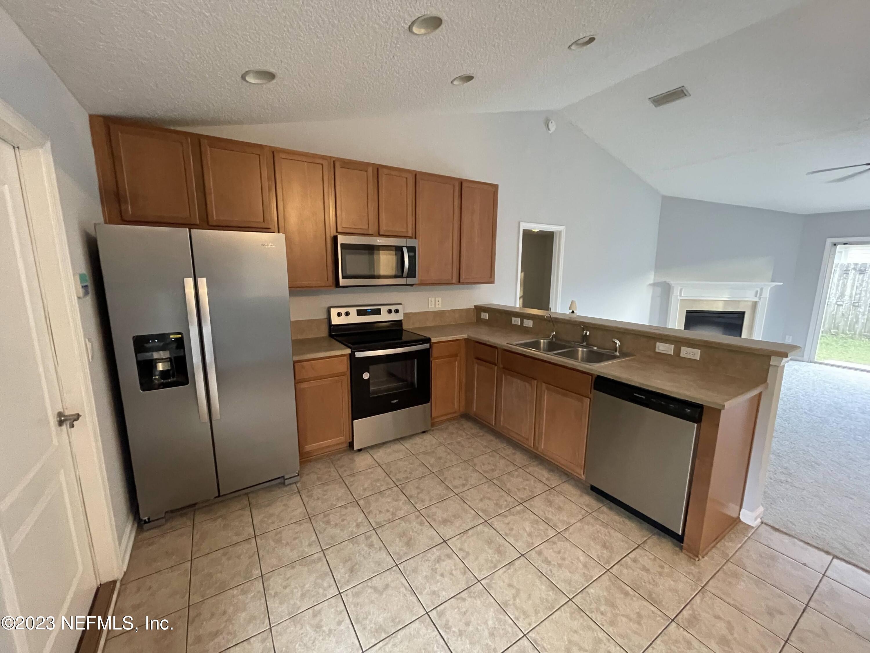 86050 Sands Way Yulee, FL 32097 - Photo 6 of 15 a kitchen with stainless steel appliances granite countertop a stove a refrigerator and a sink