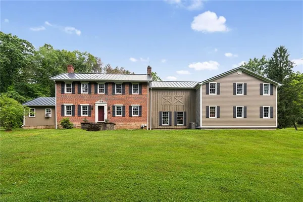 a front view of a house with a garden and trees
