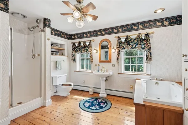 a spacious bathroom with a tub a sink and a mirror