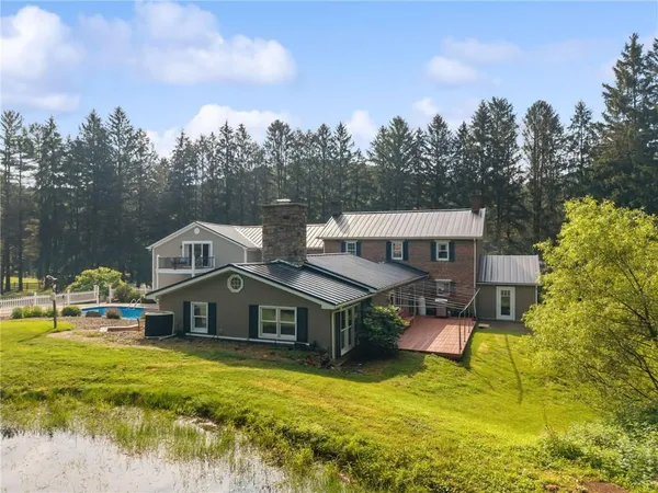 a aerial view of a house with swimming pool next to a yard