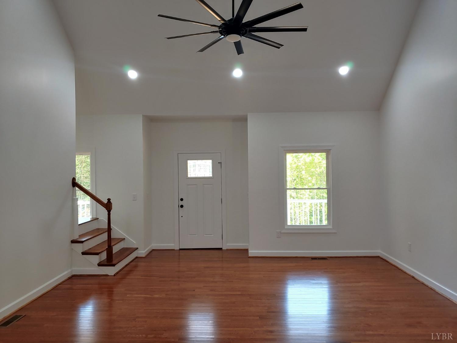 6230 Charlemont Road Goode, VA 24556 - Photo 27 of 99 an empty room with wooden floor a ceiling fan and windows