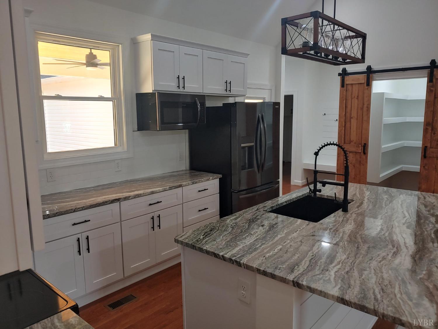 6230 Charlemont Road Goode, VA 24556 - Photo 34 of 99 a kitchen with granite countertop a refrigerator and a sink