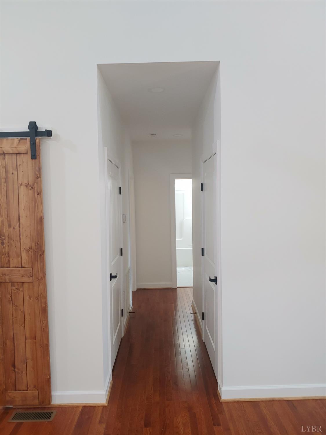 6230 Charlemont Road Goode, VA 24556 - Photo 40 of 99 a view of a hallway with wooden floor and a bathroom