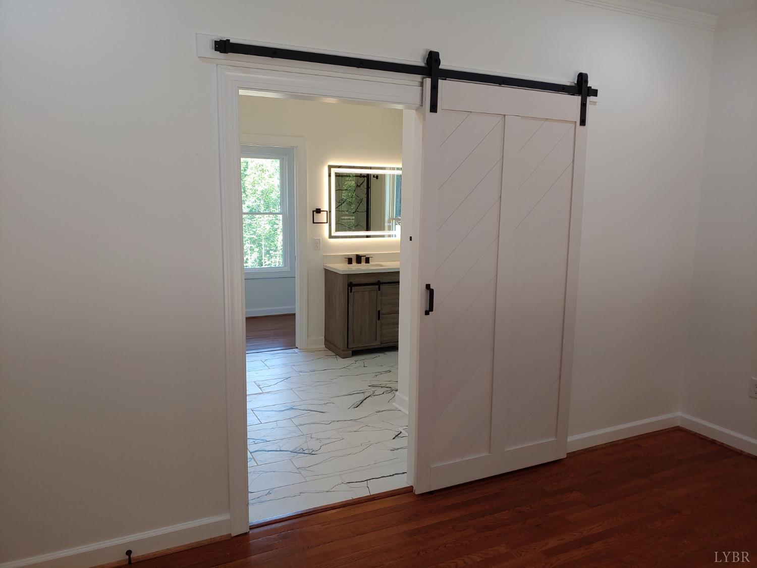 6230 Charlemont Road Goode, VA 24556 - Photo 58 of 99 a view of a hallway with wooden floor and a bathroom