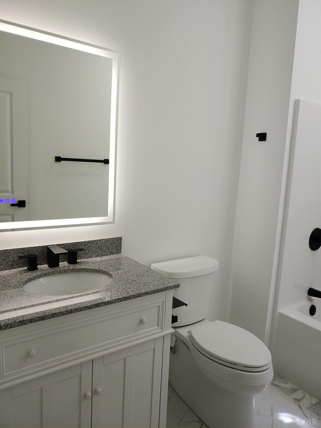 6230 Charlemont Road Goode, VA 24556 - Photo 68 of 99 a bathroom with a granite countertop toilet sink and mirror