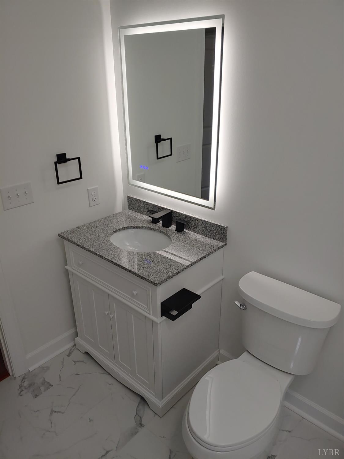 6230 Charlemont Road Goode, VA 24556 - Photo 70 of 99 a bathroom with a toilet a sink and mirror