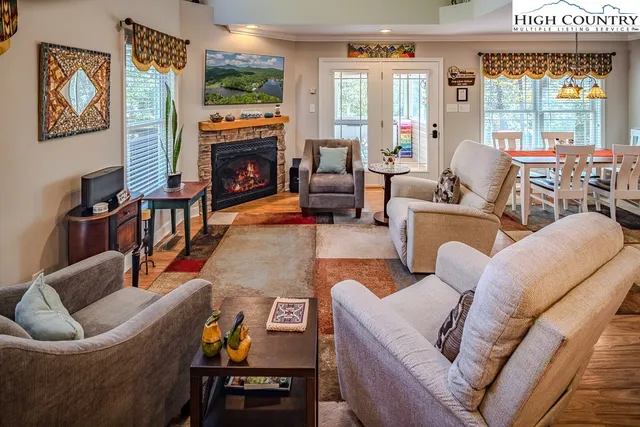 a living room with furniture fireplace and a large window