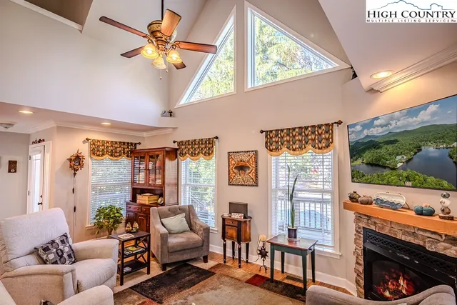 a living room with furniture a fireplace and a floor to ceiling window