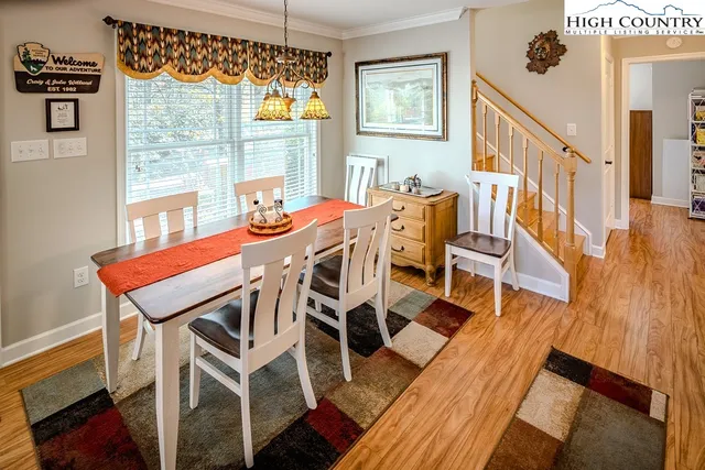 a view of a dining room with furniture a chandelier and wooden floor