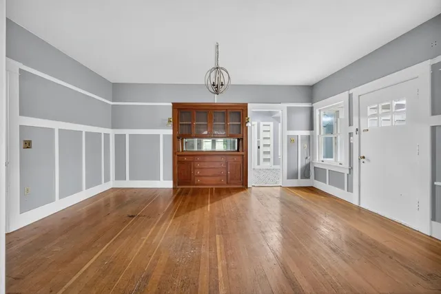 a view of a livingroom with wooden floor and a ceiling fan