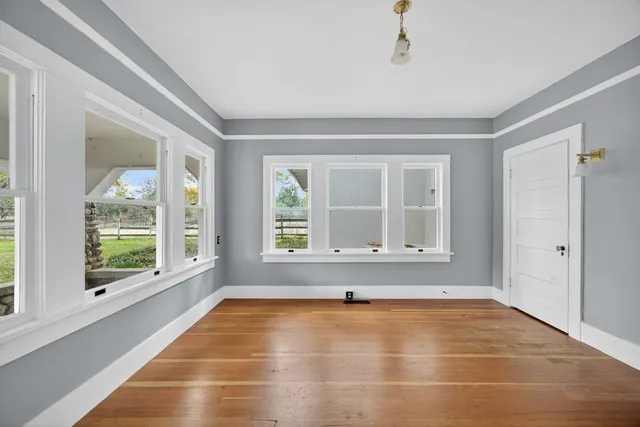 a backyard of a house with wooden fence and large trees