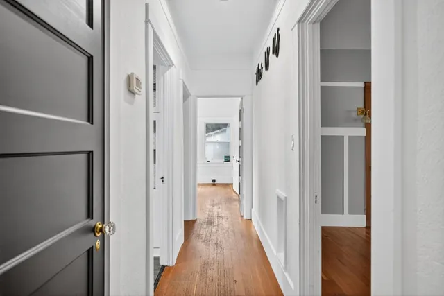 a view of a house next to a big yard with large trees and plants