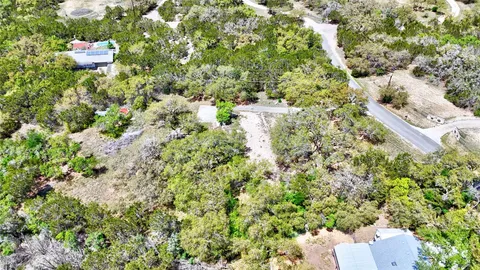 an aerial view of a houses with a yard and mountain