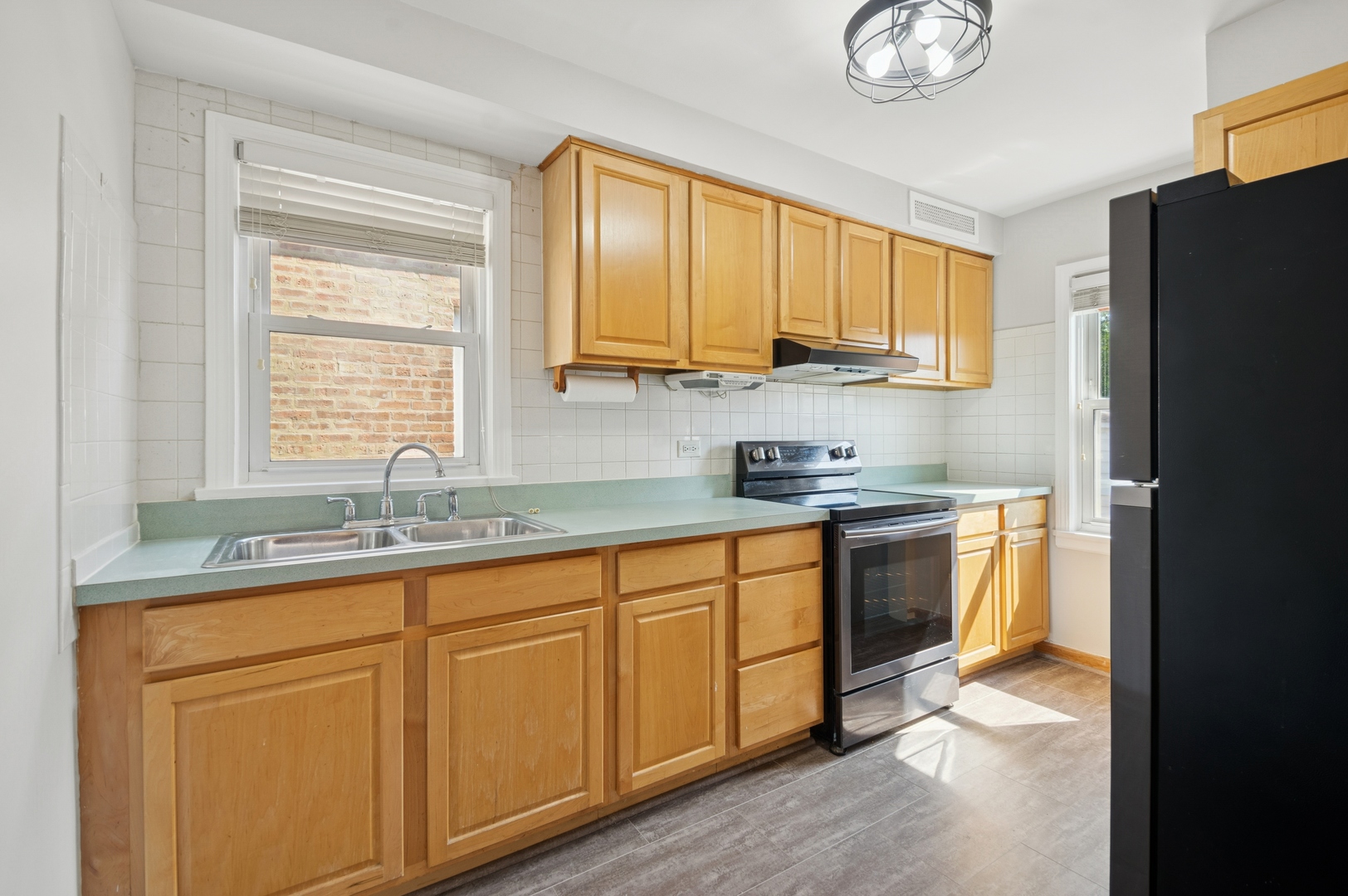 4631 North Lawler Avenue Chicago, IL 60630 - Photo 12 of 34 a kitchen with granite countertop cabinets stainless steel appliances a sink and a window