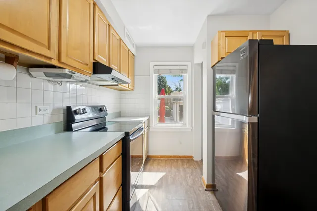 a kitchen with stainless steel appliances a refrigerator a sink and cabinets