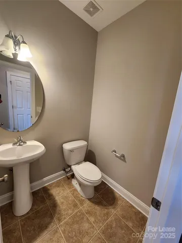 a bathroom with a sink toilet and a mirror