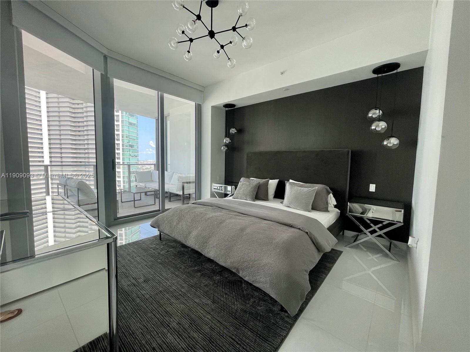 851 Northeast 1st Avenue, Unit 2403 Miami, FL 33132 - Photo 6 of 25 a bed room with a bed and a large window